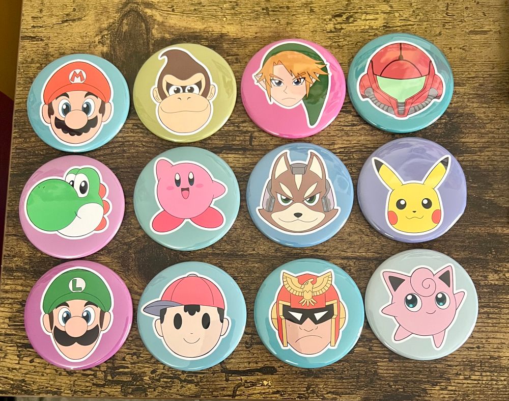 A picture of button pins featuring characters from the first Super Smash Bros game. 