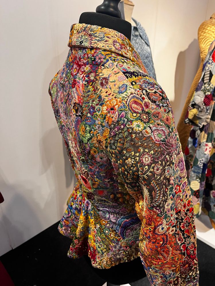 The back of the jacket showing a peplum also covered with embroidered stitches. 