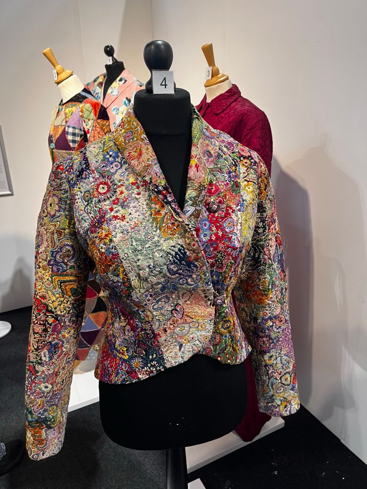 A cropped patchwork jacket covered with colourful, intricate embroidered flowers. 