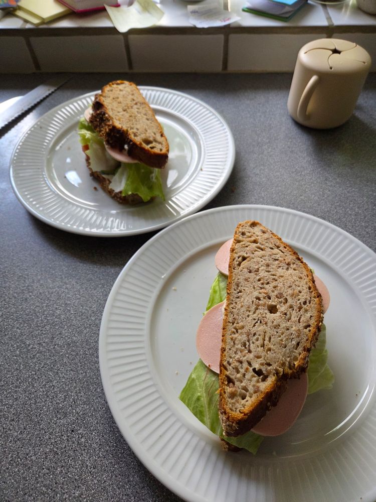 2 plates with a sourdough sandwich on each. They obviously contain sliced meat, lettuce and dressings. (Don't worry, there's also cheese 😁)