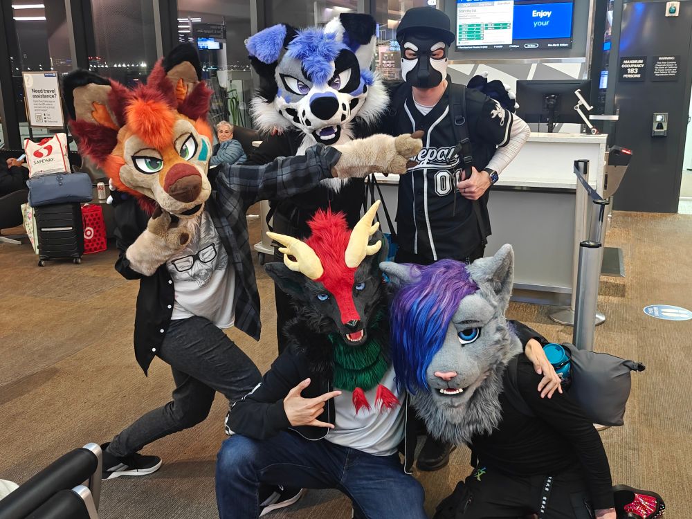 5 fursuiters posing in front of the gate at SFO Airport and some weird lady in the background looking at us like wtf xd