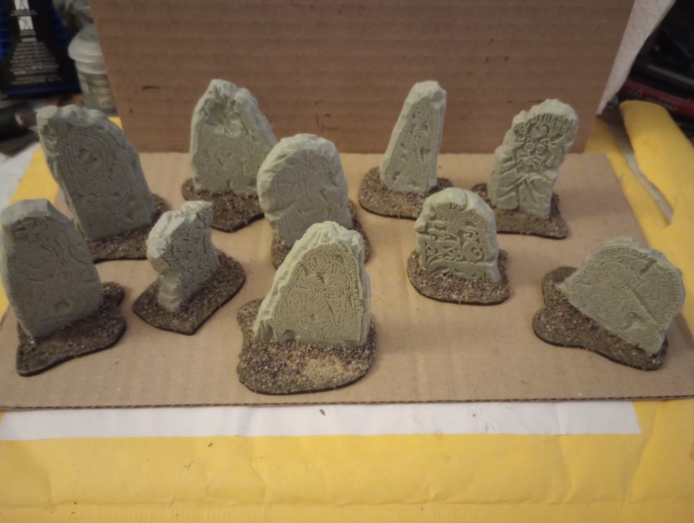 Ten resin Viking runestones, each glued to an irregularly shaped base, bases covered within sand and grit. 