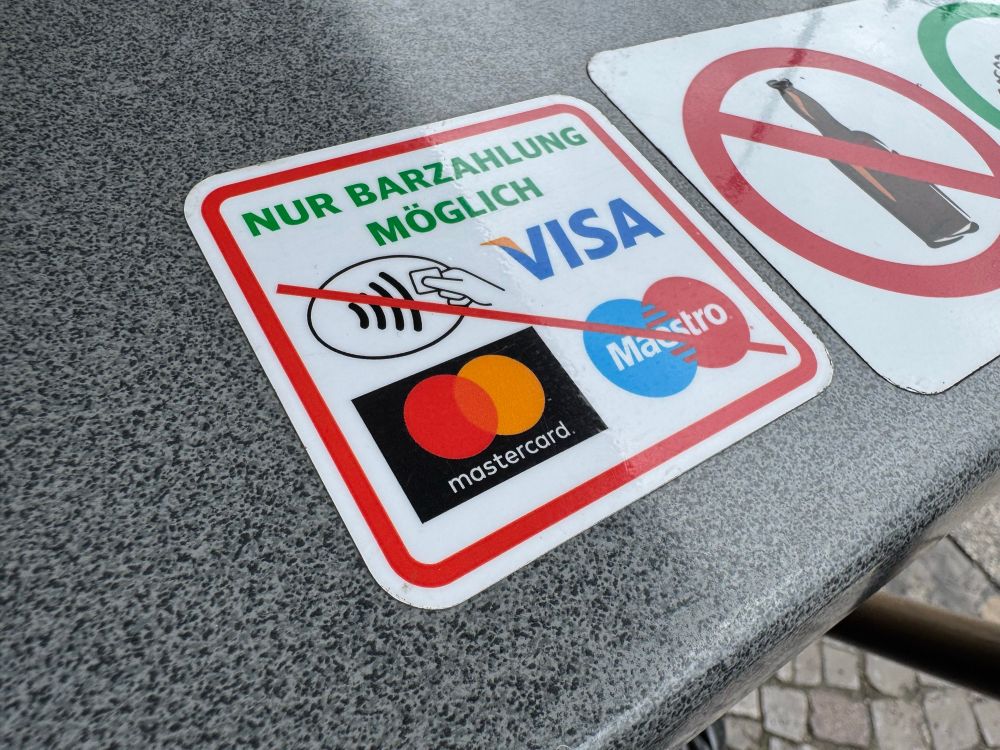 Ein Aufkleber auf einem Tisch. Alle Karten sind durchgestrichen. „Nur Barzahlung möglich“ steht dabei.