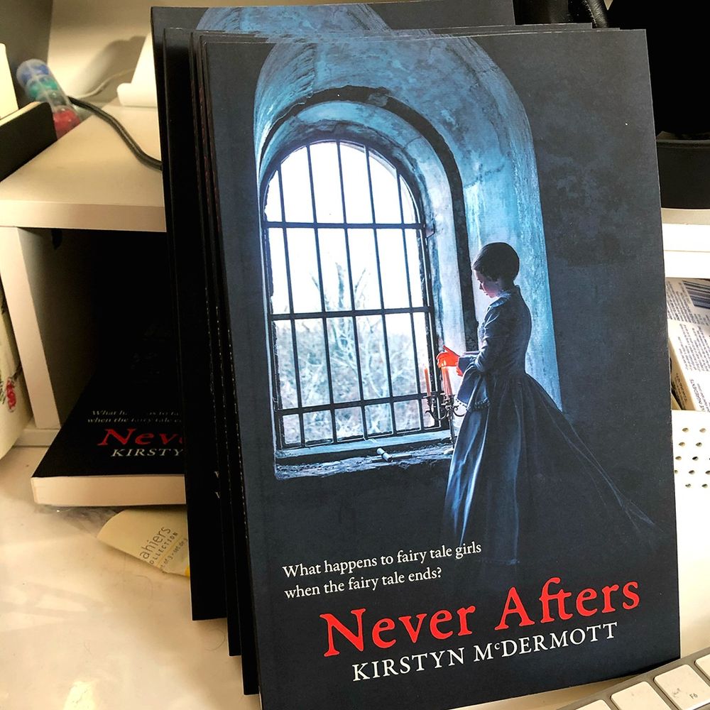 Six copies of Kirstyn McDermott's collection, Never Afters, on a busy computer desk in the Brian Jar Press offices. 