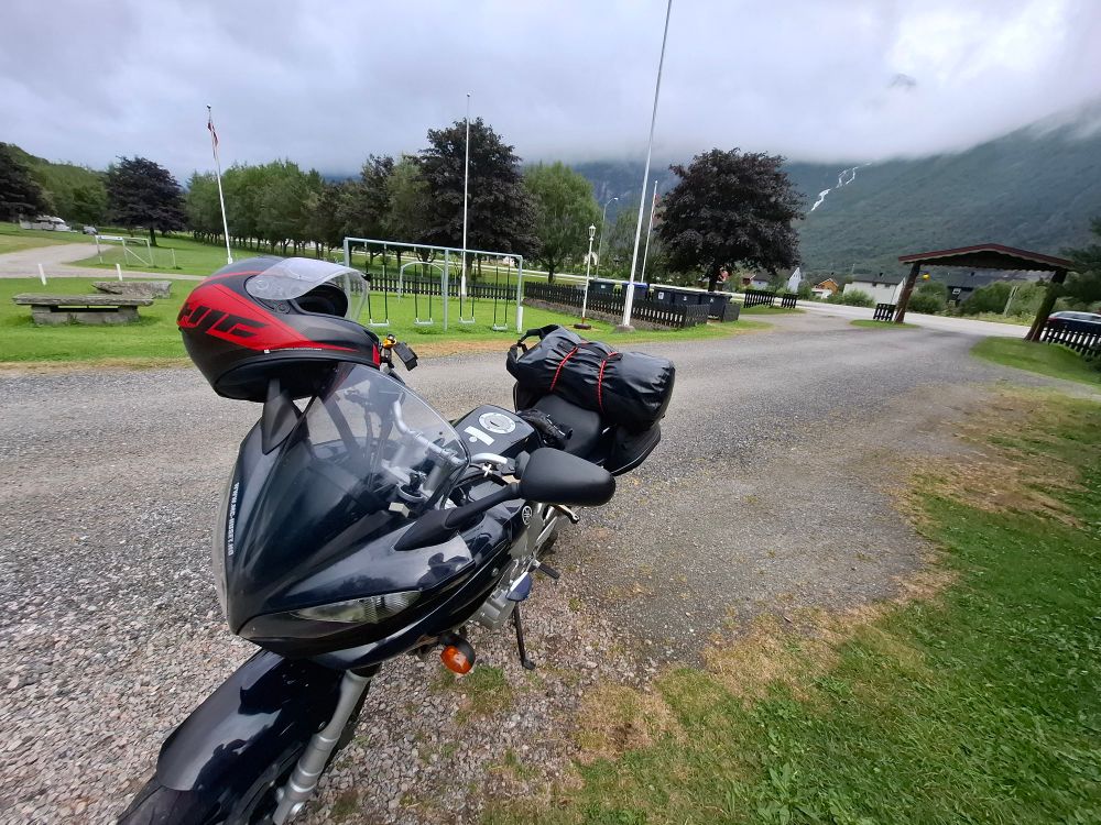 Motorbike parked at the entrance of a campsite.