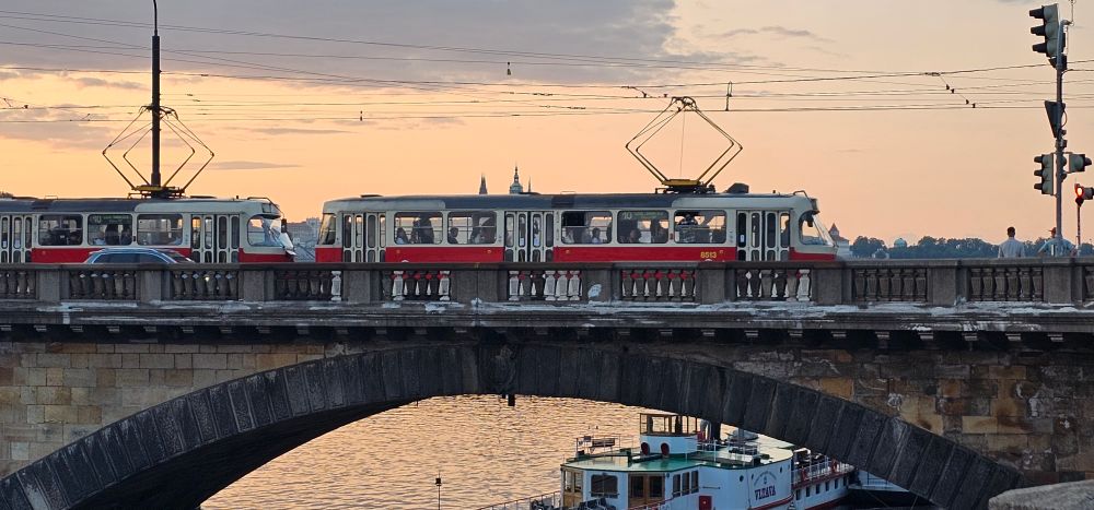 A light rail car crossing a Prague bridge near the old town.