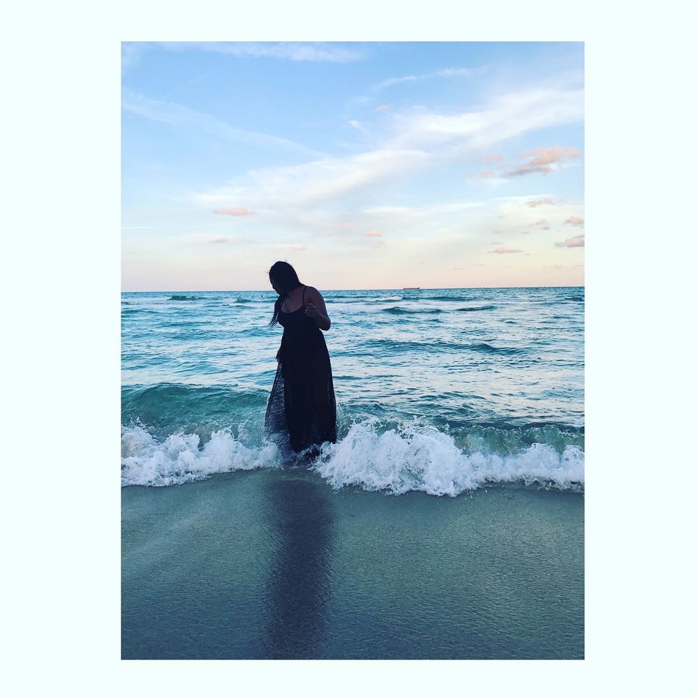 A lady in a black swimsuit on the beach 