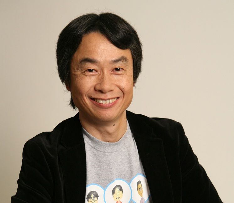 Shigeru Miyamoto in a Mii t-shirt and sports coat smiling
