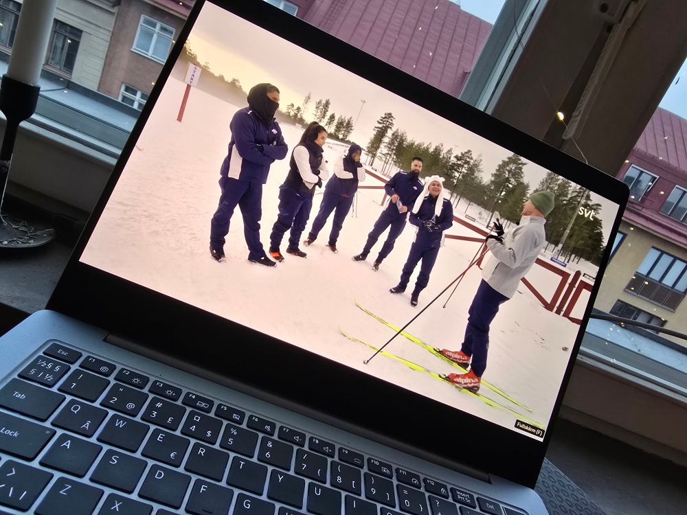 Laptop med scen ur Mot alla odds där hela gänget står och får instruktioner av Gunde Svan.