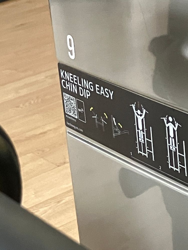 Máquina de gimnasio con el nombre de “kneeling easy chin dip”