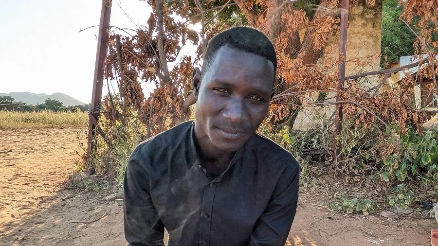 Ahmed wearing a black shirt and sitting in front of trees