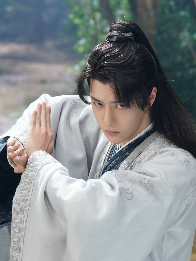 Wang Yibo in costume dressed as Xie Yun from 《Legend of Fei》posed in a stance like he's about to do some sort of martial arts move.