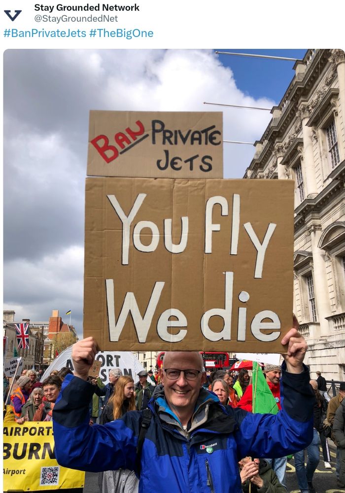Demonstrant mit Schild you fly we die , Ban Privatjets .