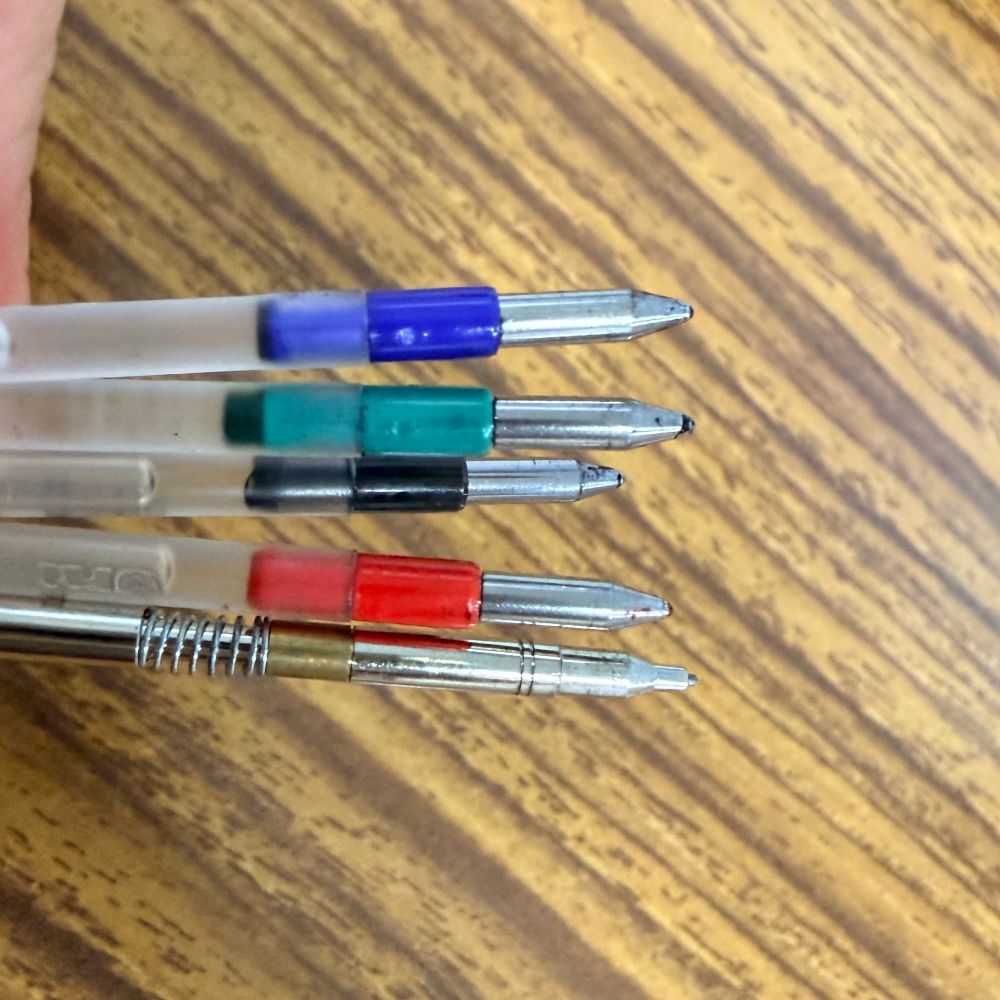 4色ボールペンを分解したところの写真。黒、赤、青、緑のインク残量がもう無い