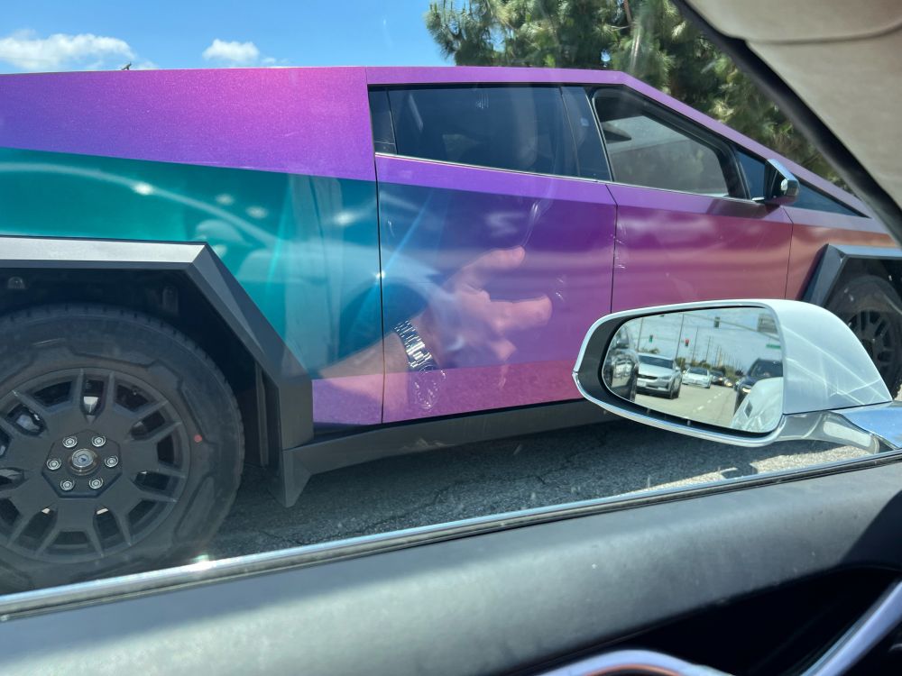A cybertruck with one of those paint jobs that changes color when you look at it from different angles