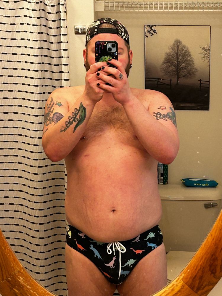 Mirror selfie in dinosaur print swim briefs 