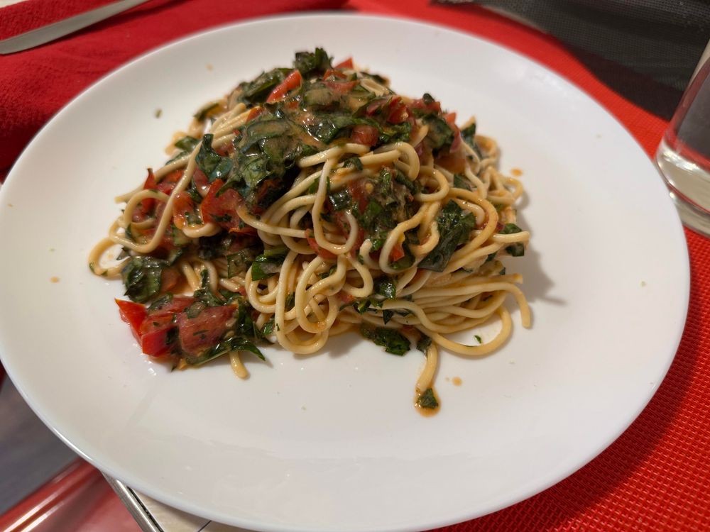 The spaghetti plated. It’s sauced with a huge bunch of chopped basil, some fresh tomatoes, and a good amount of hot olive oil wilting the previous items. 