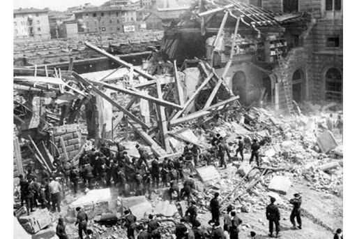 The part of the Bologna Station building that collapsed seen from the outside with rescue workers digging through the rubble.
