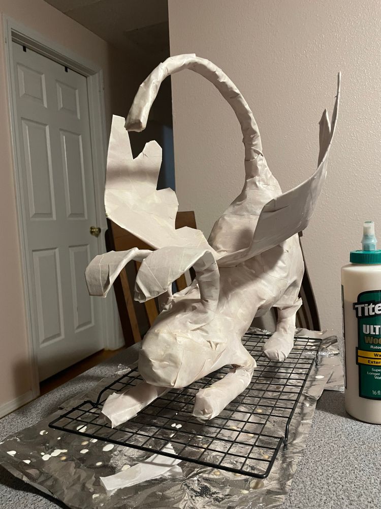 A paper mache bunny with a long tail and wings on its back