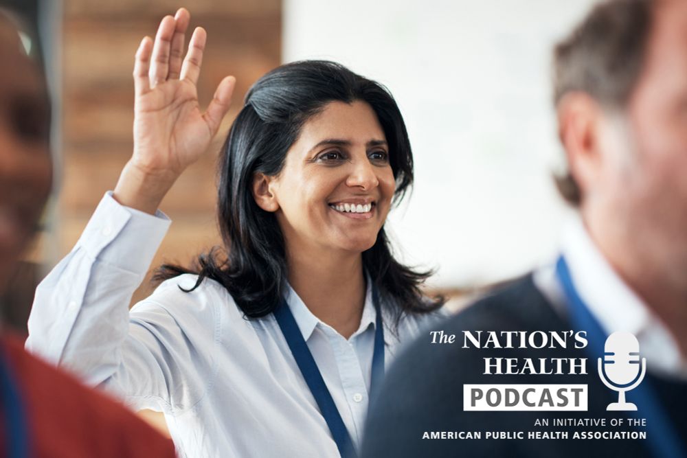 Smiling woman raises hand in a crowd. The Nation’s Health Podcast logo.