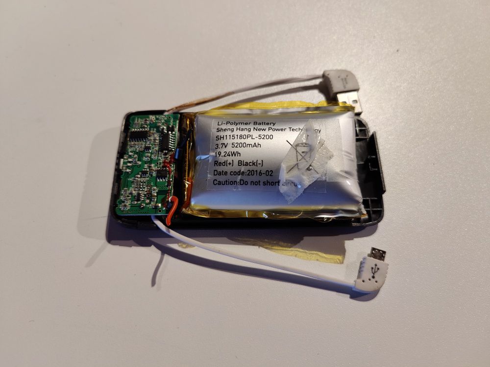 Vanha varavirtalähde aukaistuna, litium-akku pullistunut tyynyn malliseksi.