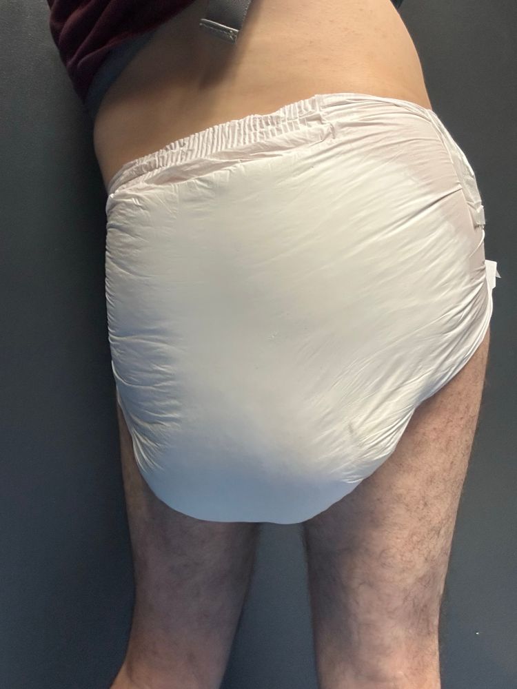 Wearing a soaked yellow giraffe ABU Peekabu diaper, size medium, view of back.