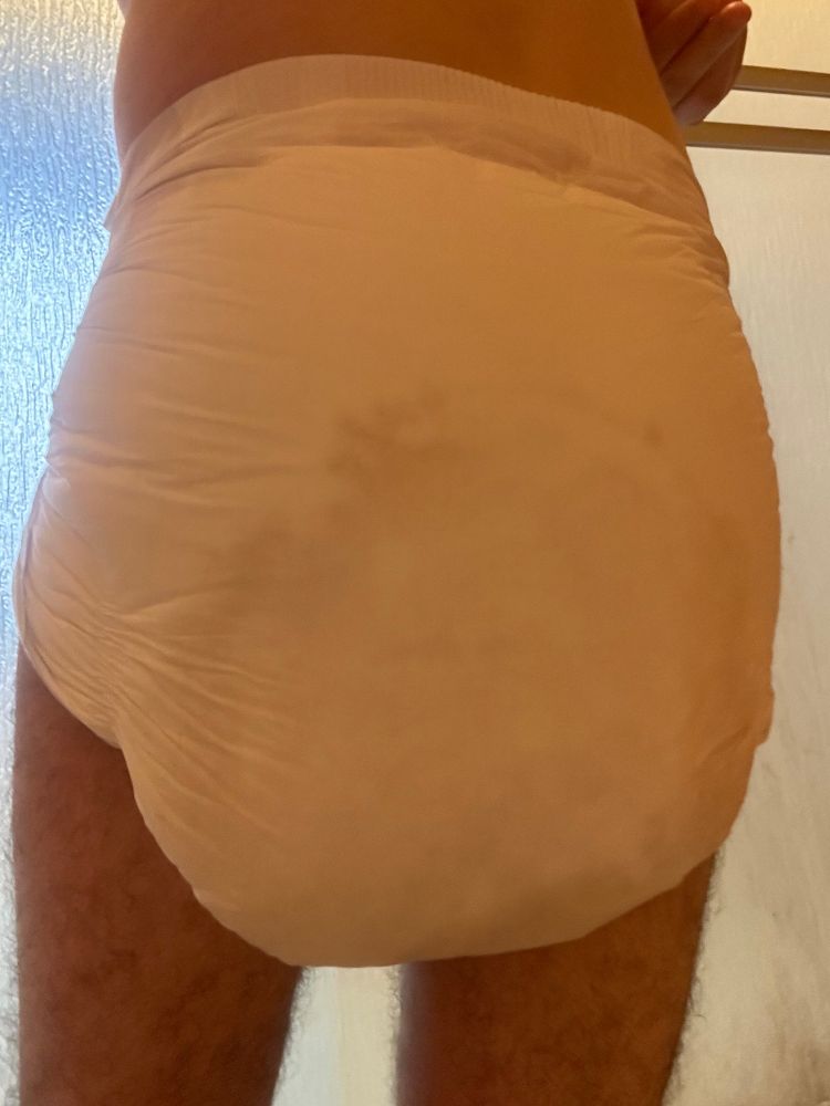 Guy in a wet Str8up diaper, size medium, view of butt.  The wetness can be seen more than halfway up the diaper, in a curving shape.