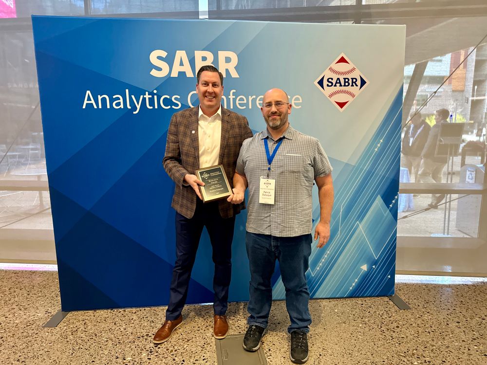 SABR CEO Scott Bush presents Patrick Dubuque of Baseball Prospectus with his 2025 SABR Analytics Conference Research Award.