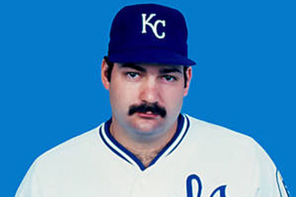 Headshot photo of Steve Balboni, a large, mustachioed man in a white Kansas City Royals uniform and blue cap from the mid-1980s.