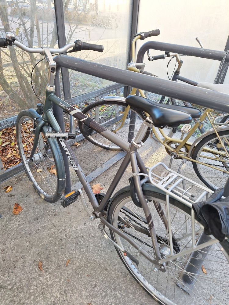 Polkupyörä katetussa fillariparkissa putkilukolla kiinni telineessä