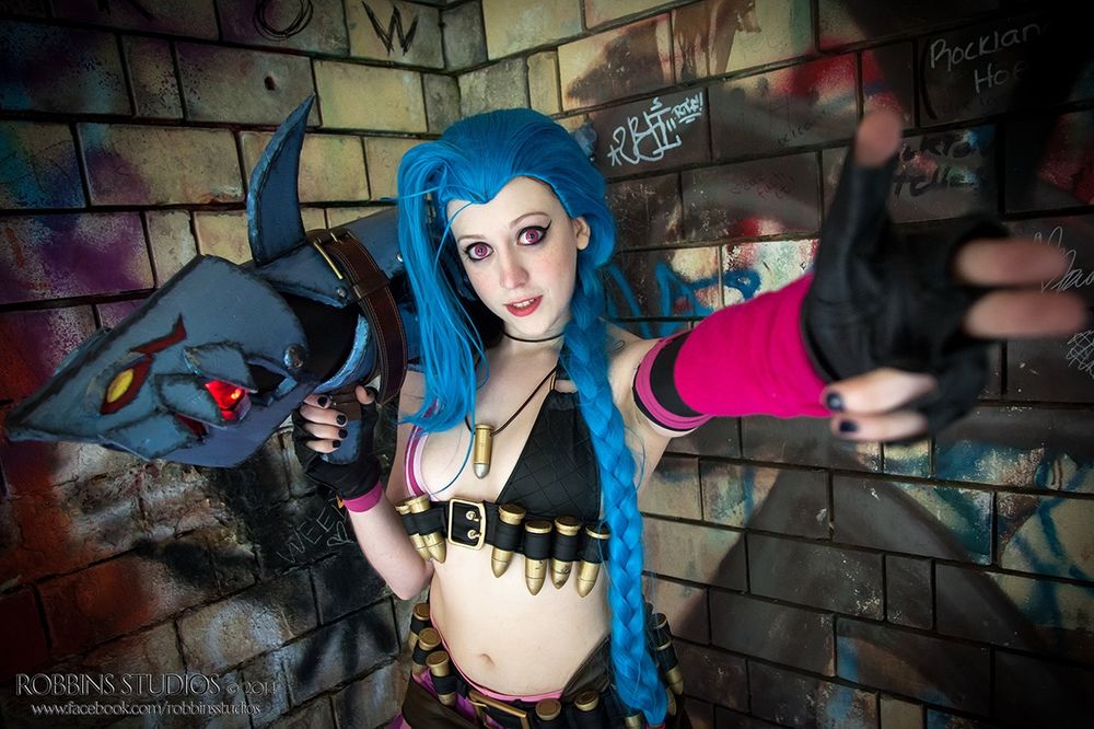Leeleethebunny as Jinx from League of Legends posing with her rocket launcher Fishbones against a graffiti covered wall