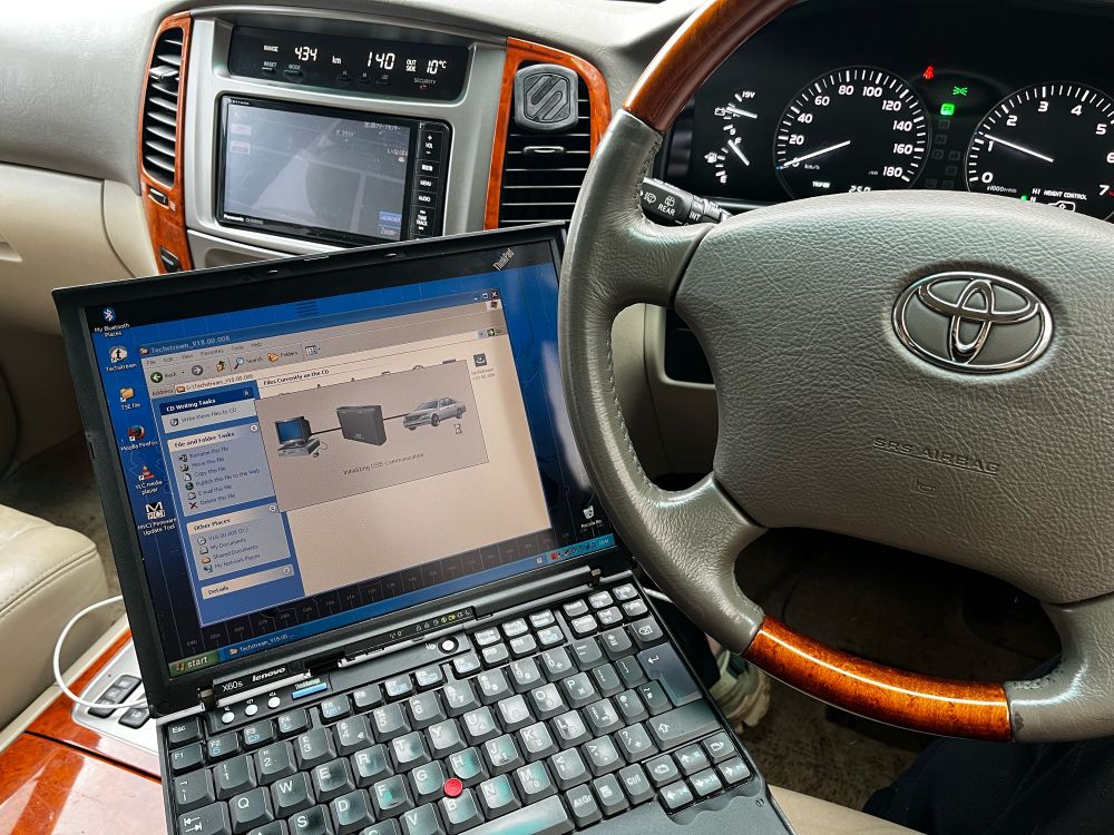 the interior of a 2006 land cruiser, with a vintage thinkpad running xp and toyotas techstream software 