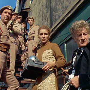Dr Elizabeth Shaw, flanked by The Third Doctor, Brigadier Lethbridge-Stewart, and several UNIT soldiers