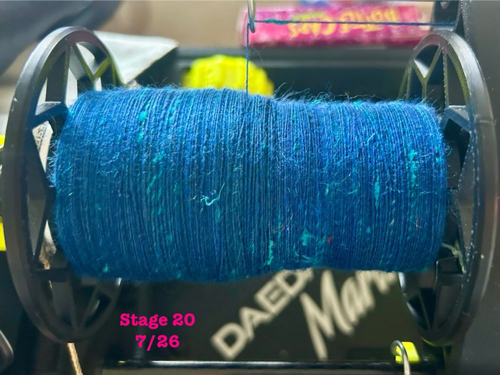 Handspun yarn singles, under layer royal blue, surface layer teal-blue going into teal. Bright blue sari silk slubs throughout.