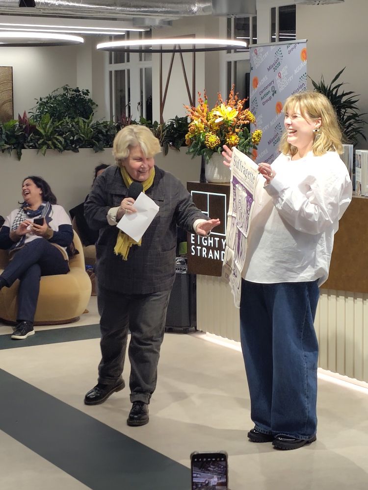 Picture of comedian Sandi Toksvig making a joke that the suffragette poster is printed on a tea towel.
