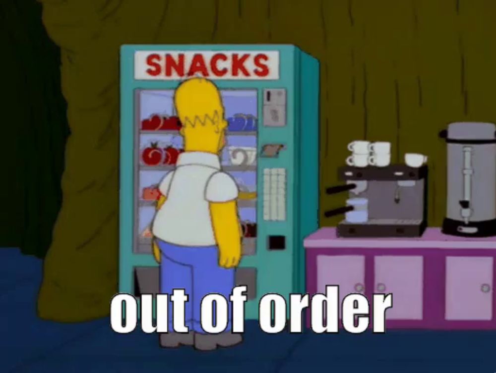 homer simpson standing in front of a snacks machine