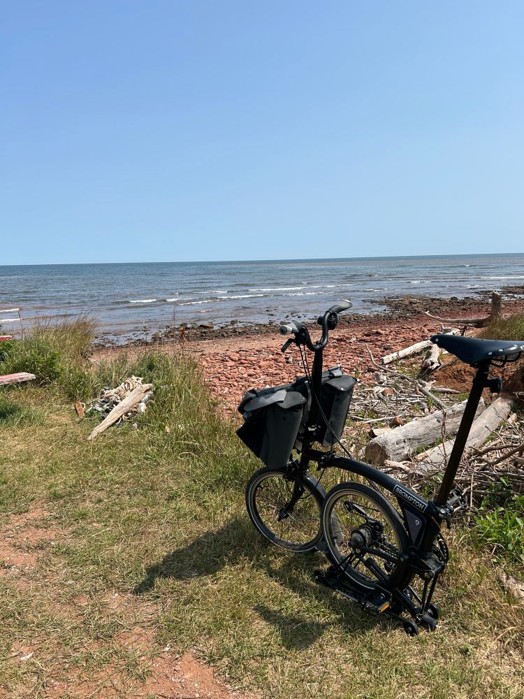 A partially folded Brompton with the beach and gulf of St Lawrence in the background 