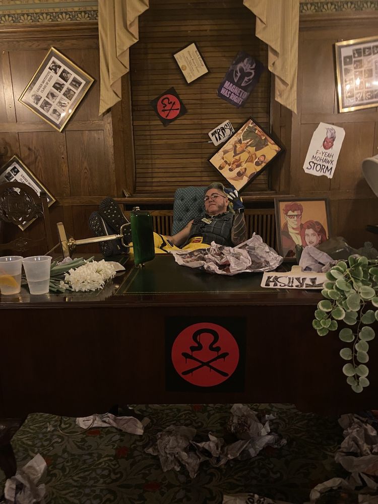 Me (now with a denim vest on 'cause I got gussied up for the Hellfire Club) posed with my feet up on the professor's trashed desk at the afterparty.