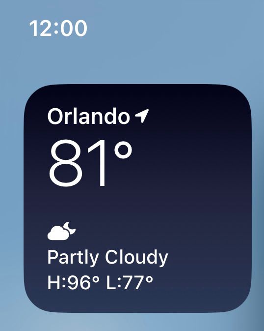 Cropped screenshot of the iPhone Weather widget just below the phone’s time showing 12:00 (midnight).  The widget shows Orlando is currently 81° and partly cloudy with an expected high of 96° and expected low of 77°.