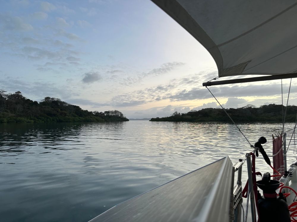 Grey twilight sky with a hint of color highlighting lenticular clouds. Water in the foreground is barely rippled. Sunset on Feb 14 in Las Perlas, Panama 