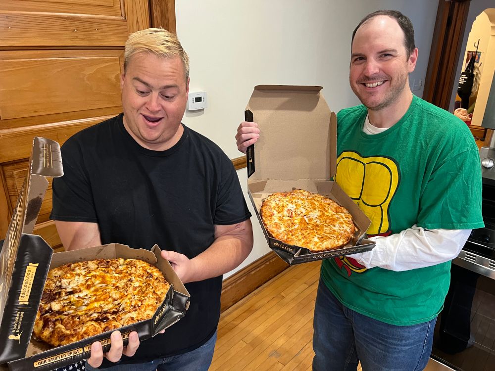 The hosts of Show Me the Franchise podcast, Fred Dakin and Tom Stadler, each holding a pizza