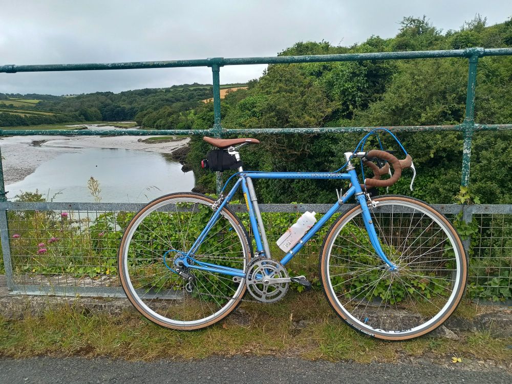Peugeot P10 bike leaning on a bridge railing 