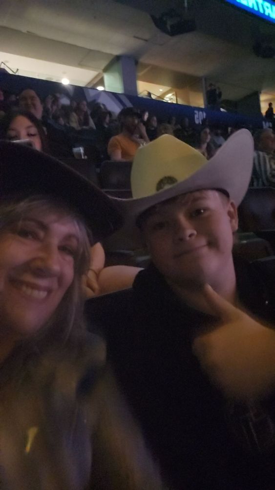 Selfie of my mom in a cowboy hat with Lucas in a cowboy hat, giving the thumbs up.