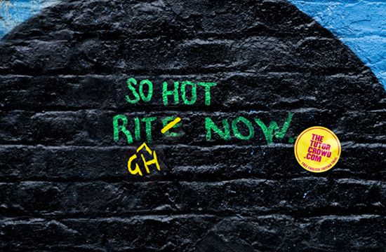 Image shows graffiti on a wall. In green it is written: 'So hot rite now'. Yellow writing is used to change the non-standard spelling from 'rite' to 'right'.