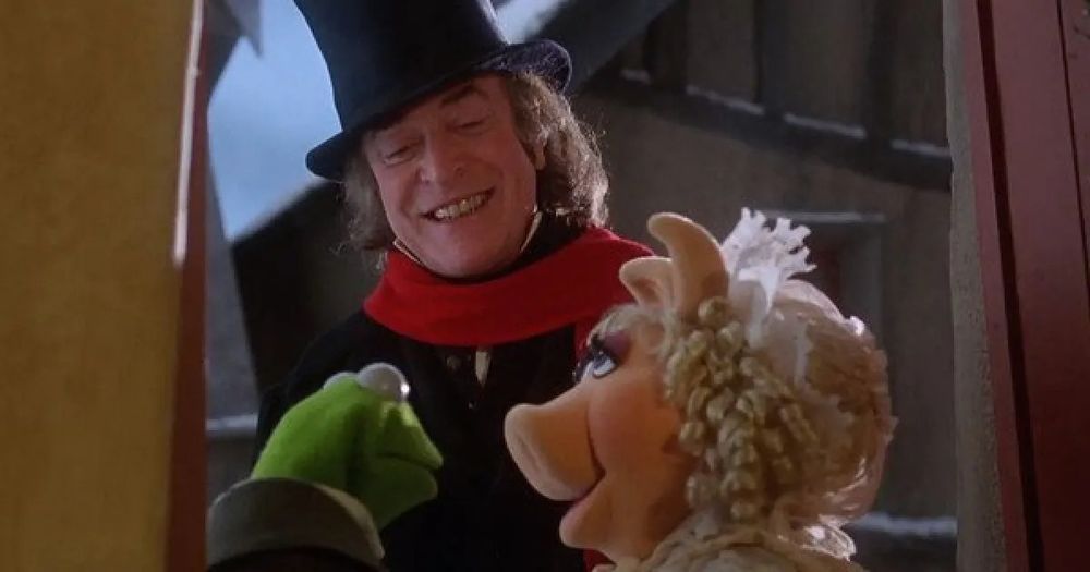 A still from the film A Muppet Christmas Carol, in which Bob Cratchit (Kermit) and his wife (Mrs Piggy) open the door to Bob's boss Scrooge (Michael Caine) 