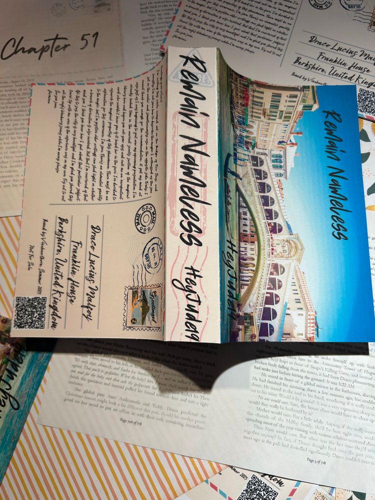 Photograph of a bind of Remain Nameless designed to look like a post card from Venice. This photo has the book open with the spine in the middle, front cover on the right and back cover on the left. 