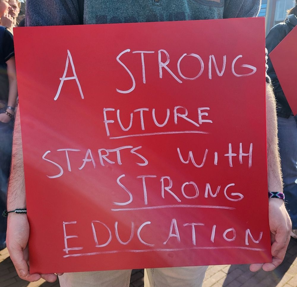 Red sign with white letters: A Strong Future Starts With Strong Education