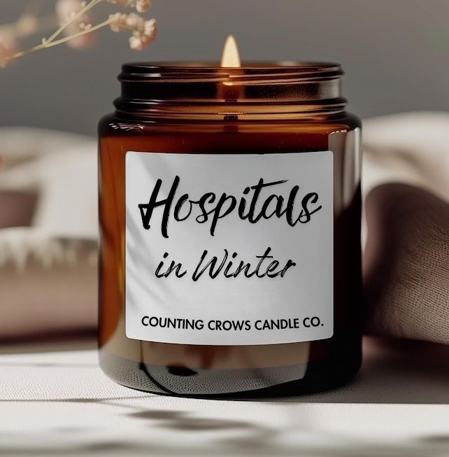 A scented candle burning in a nice cozy homey kinda setting. Amber glass jar, label reads 