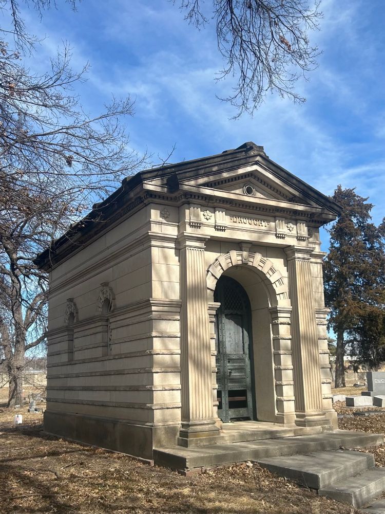 Old stone mausoleum with bronze doors.