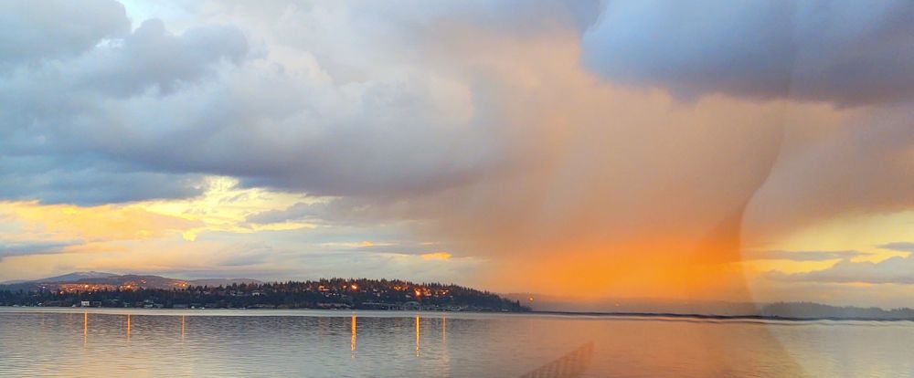 Red and blue cloudburst at sunset over Lake Washington.